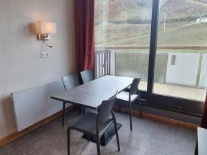 einen Tisch und Stühle in einem Zimmer mit Fenster in der Unterkunft Studio Plagne Aime 2000, 1 pièce, 4 personnes - FR-1-181-2585 in Aime La Plagne