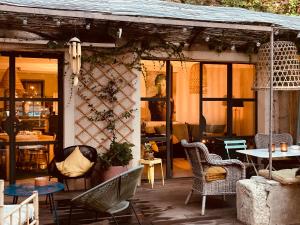 a patio with wicker chairs and tables and a building at Casa 55 in Tulette