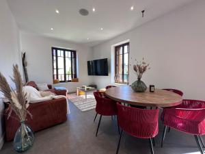 a living room with a table and red chairs at Maison de ville Duplex Artienzo in Sarlat-la-Canéda