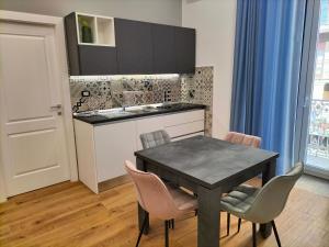 cocina con mesa, sillas y fregadero en Place de Rome, en Barletta