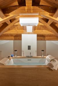 uma banheira num quarto com tecto em madeira em Relais - Palazzo Greco Stella em Lamezia Terme