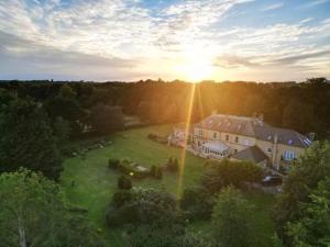 an aerial view of a large house with the sun setting at Broom Hall Country Hotel in Saham Toney