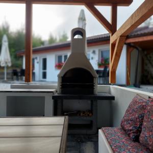 einen Pizzaofen im Freien auf einer Terrasse mit einem Sofa in der Unterkunft Apartmány nad Tajovom in Banská Bystrica
