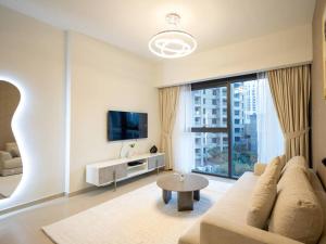 een woonkamer met een bank en een tv bij MH - Act One Act Two - DownTown - 1BHK - REF505 in Dubai