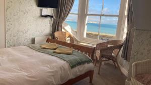 a bedroom with a bed with a view of the ocean at Whitecliff Guest House in Weymouth