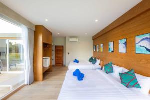 ein Schlafzimmer mit 2 Betten und blauen Kissen darauf in der Unterkunft Vann House Chiang Rai- near Mae Fah Luang University in Chiang Rai