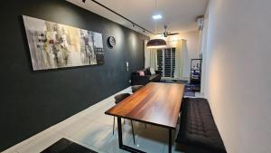 a living room with a wooden table and a couch at Serenestay Cozy Studio @ Southville City in Kajang