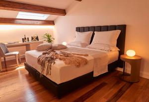 a bedroom with a large bed and a desk at Relais - Palazzo Greco Stella in Lamezia Terme