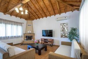 a living room with two couches and a tv at Four Seasons Villas in Skiathos Town
