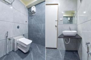 a bathroom with a toilet and a sink and a mirror at FabHotel Bliss in Ahmedabad