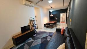 a living room with a couch and a television at Serenestay Cozy Studio @ Southville City in Kajang