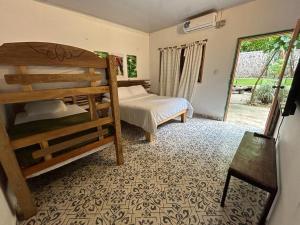a bedroom with two bunk beds and a bedroom with a window at Costeño River Minca in Minca