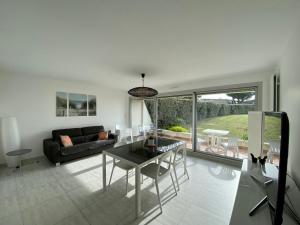 a living room with a table and a couch at Les Dunes, appartement moderne au bord de l’eau in Larmor-Plage