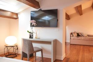 a living room with a table and a tv on the wall at Relais - Palazzo Greco Stella in Lamezia Terme