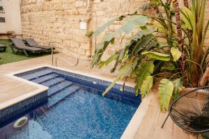 een zwembad in het midden van een tuin met planten bij Astuto Boutique Jerez - Adults Only in Jerez de la Frontera