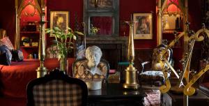 una sala de estar con una cama y un busto en una mesa en The Witchery by the Castle, en Edimburgo