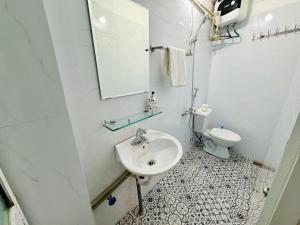 een witte badkamer met een wastafel en een toilet bij Local Me - Exclusive Centre Room in Hai Phong