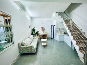 een woonkamer met een bank en een trap bij Local Me - Exclusive Centre Room in Hai Phong