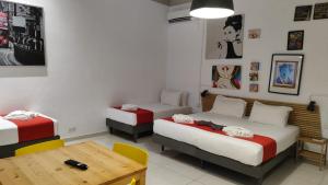 a room with two beds and a wooden table at Cresta Beach Studios in St. Julianʼs