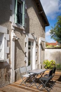 una mesa y sillas sentadas en el porche de un edificio en NATURE, en Cosne-Cours-sur-Loire