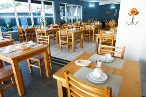 a dining room with wooden tables and chairs at São Roque Park Hotel in São Roque