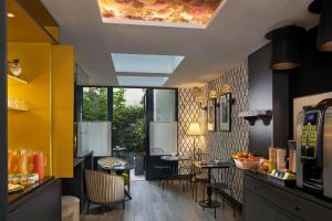 un restaurante con paredes amarillas, mesas y sillas en Les Plumes Hotel en París