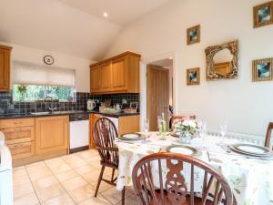een keuken met een tafel en stoelen en een keuken met een aanrecht bij Abbey View Farm Cottage in Uttoxeter