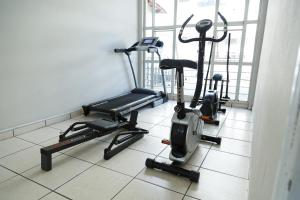 um ginásio com três bicicletas de exercício num piso de azulejo em São Roque Park Hotel em São Roque