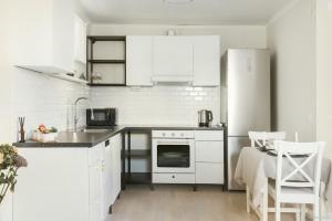 una cucina con elettrodomestici bianchi, tavolo e sedie di Charming apartment in a red house in Stockholm a Stoccolma