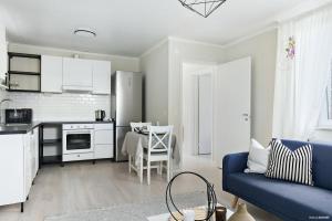 una cucina e un soggiorno con divano blu di Charming apartment in a red house in Stockholm a Stoccolma