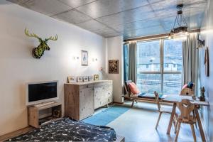 - un salon avec une télévision, une table et un canapé dans l'établissement Living Kampill, à Bolzano