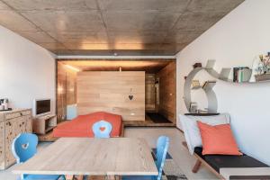 a living room with a table and a bedroom at Living Kampill in Bolzano