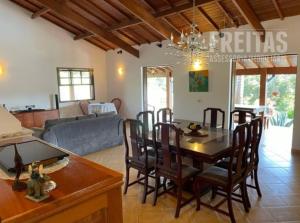 een eetkamer en een woonkamer met een tafel en stoelen bij Chácara Restinga Verde - São Roque / SP in São Roque
