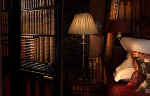 a bedroom with a bed and a lamp and books at The Witchery by the Castle in Edinburgh
