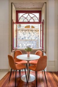 mesa y sillas en una habitación con ventana en Discovery | Porto-Flores, en Oporto