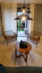 un soggiorno con tavolo, sedie e lampadario pendente di Buena vista PB - Bon Repos a Yerba Buena
