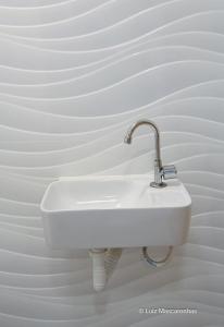a white sink on a white wall at Village 2 suítes beira mar Itacimirim in Camaçari