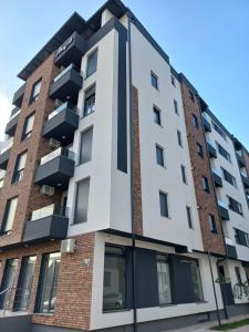 a building with balconies on the side of it at Apartman Arija in Ruma