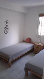 a bedroom with two twin beds and a window at Apartman Arija in Ruma