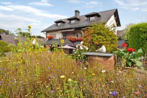 a house with a field of flowers in front of it at Ruhrtalblick in Bestwig