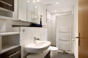 a white bathroom with a sink and a toilet at Ruhrtalblick in Bestwig +12 photos