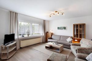 a living room with a couch and a tv at Ruhrtalblick in Bestwig