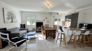 a living room and kitchen with a couch and a table at L'Appart de nos 2 vies in Le Crotoy +21 photos