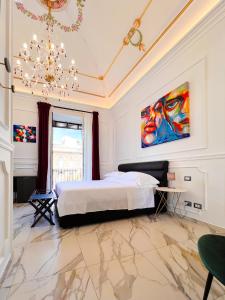 um quarto com uma cama e um quadro na parede em Ricci Palace Suites em Catânia
