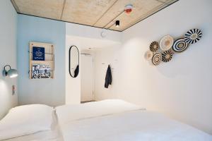 a bedroom with white walls and two white beds at Villa Viva - ein Haus das Brunnen baut in Hamburg