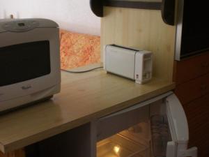 una scrivania con forno a microonde e monitor per computer; di Studio Valloire, 1 pièce, 4 personnes - FR-1-263-477 a Valloire