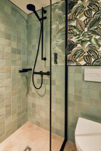 a bathroom with a shower with a toilet at Villa Viva - ein Haus das Brunnen baut in Hamburg