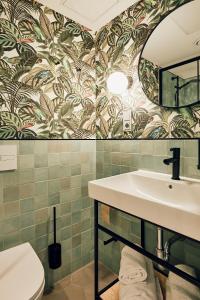 a bathroom with a sink and a mirror at Villa Viva - ein Haus das Brunnen baut in Hamburg