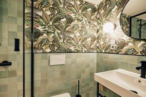 a bathroom with a toilet and a sink and a mirror at Villa Viva - ein Haus das Brunnen baut in Hamburg