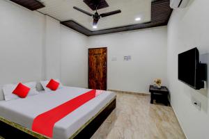 a bedroom with a bed and a ceiling fan at OYO Flagship Hotel Galaxy in Nagpur